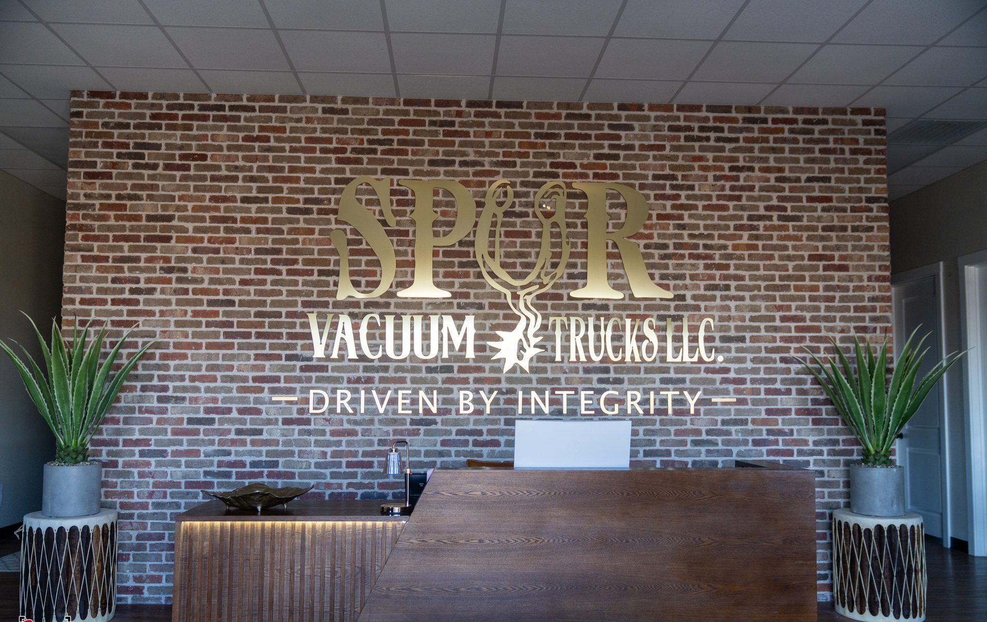 Spur Vacuum Trucks branded reception lobby with Driven by Integrity signage
